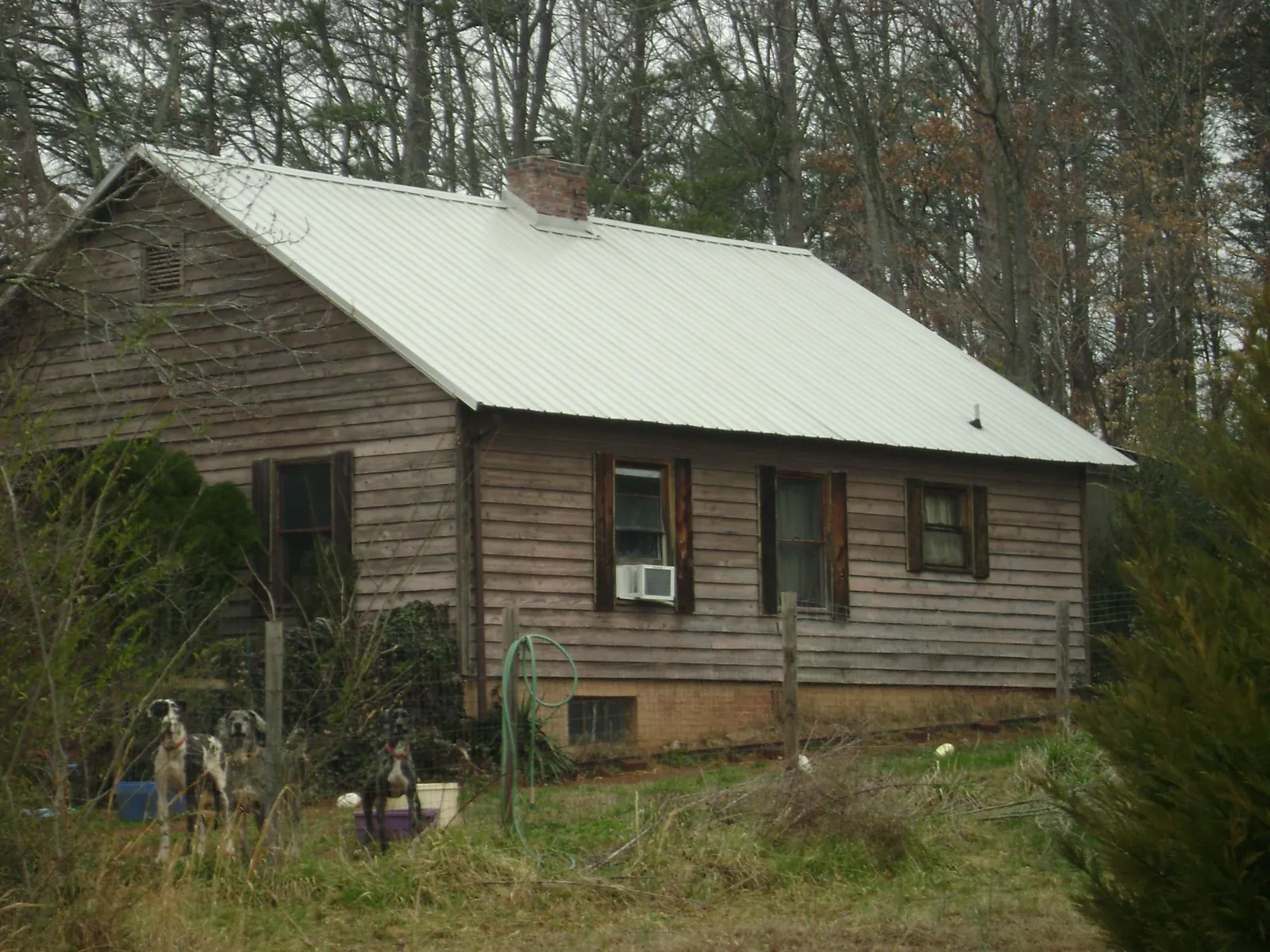 White metal roof on an old wood sided farmhouse, from a Metal Roof Installation job in Cascade